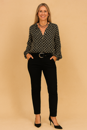 Zwarte blouse met lange mouwen, V-hals en beige kettingpatroon, uitgevoerd in luchtige stof met licht glanzende afwerking.