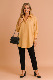 Zachte blouse in warme mosterdkleur met lange mouwen, een nette kraag en clean afgewerkte knoopsluiting. De rechte, oversized pasvorm maakt het ideaal voor een smart casual look.