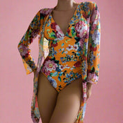 Oranje bloemenprint badpak met diepe halslijn en transparante kimono cover-up