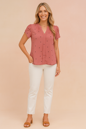 Oudroze blouse met korte mouwen, hartjesprint, zachte plooien en schouderdetails voor een romantische stijl.