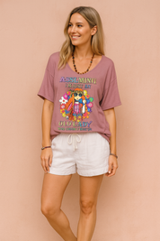Vintage oudroze dames-T-shirt met diepe V-hals, losse pasvorm en kleurrijke hippieprint met bloemen en tekst “Assuming I’m just an old lady”, gemaakt van lichtgewicht ademende stof voor een casual zomerse look.