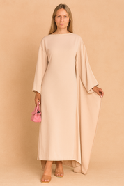 Lange beige jurk met wijde vleermuismouwen en rechte pasvorm, ideaal voor formele gelegenheden.