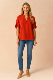 Effen rode blouse met stijlvolle V-halsuitsnijding en korte mouwen met een subtiele omslag. Gemaakt van een soepele stof met een licht glanzende afwerking.