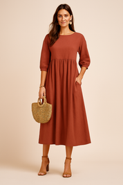 Roestbruine midi-jurk met 3/4-mouwen, geplooide taille en natuurlijke linnenstructuur.