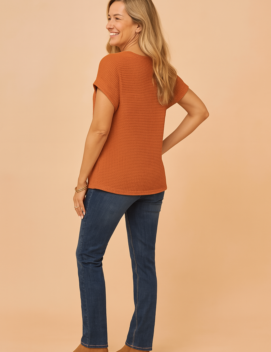Roestkleurig dames T-shirt met wafelstructuur en korte opgerolde mouwen, achteraan langer vallend voor extra bedekking en comfort. Casual top met een rechte pasvorm.