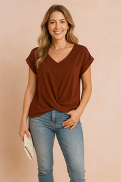 Roodbruine damesblouse met V-hals en korte opgerolde mouwen, afgewerkt met een elegante twistzoom aan de voorkant. Gemaakt van een gladde, effen stof voor een verfijnde uitstraling.