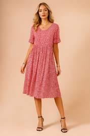 Midilang roze bloemenjurk met korte mouwen en speels wit bloemenmotief, ideaal voor lente en zomer.