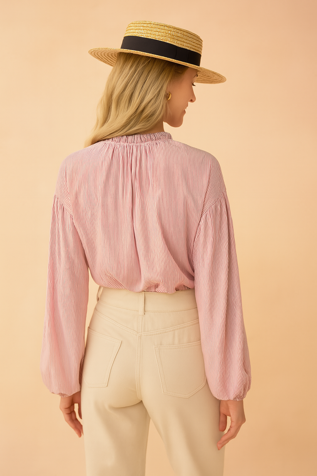 Roze damesblouse met subtiele verticale streepstructuur, gemaakt van een luchtige geweven stof. Voorzien van lange ballonmouwen met elastische manchetten, knoopsluiting aan de voorkant en een opstaand rufflekraagje met keyhole-detail. De losvallende pasvorm zorgt voor een vrouwelijke en stijlvolle uitstraling.