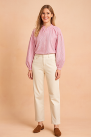 Roze damesblouse met subtiele verticale streepstructuur, gemaakt van een luchtige geweven stof. Voorzien van lange ballonmouwen met elastische manchetten, knoopsluiting aan de voorkant en een opstaand rufflekraagje met keyhole-detail. De losvallende pasvorm zorgt voor een vrouwelijke en stijlvolle uitstraling.