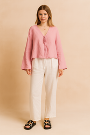 Losvallende roze blouse met striksluiting aan de voorkant, lange mouwen en licht kreukeleffect in luchtige linnenmix.