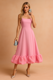 Roze midi-jurk met smalle bandjes, aansluitend lijfje en opvallende ballonzoom in organza-look.