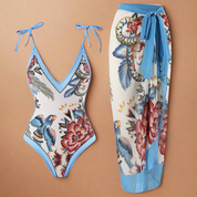 Zwempak met blauwe randen en tropische bloemenprint, gecombineerd met semi-transparante pareo in bijpassende kleuren