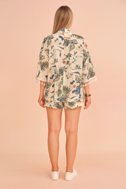 Kimono-blouse met tropische print, korte mouwen en kwastjes, gestyled met bijpassende high-waist short voor een luchtige resortlook.