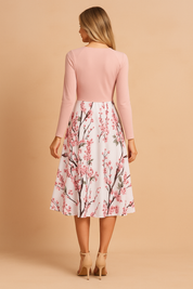 Mouwloze roze midi-jurk met spaghettibandjes en een bloesemprint in roze en groen over de hele stof, ontworpen met een flatterende A-lijn snit.