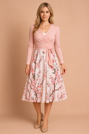Mouwloze roze midi-jurk met spaghettibandjes en een bloesemprint in roze en groen over de hele stof, ontworpen met een flatterende A-lijn snit.