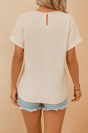 Beige gehaakte blouse met korte mouwen en opvallend kantdetail aan de voorzijde in een bohemian patroon, gemaakt van luchtige, gebreide stof.