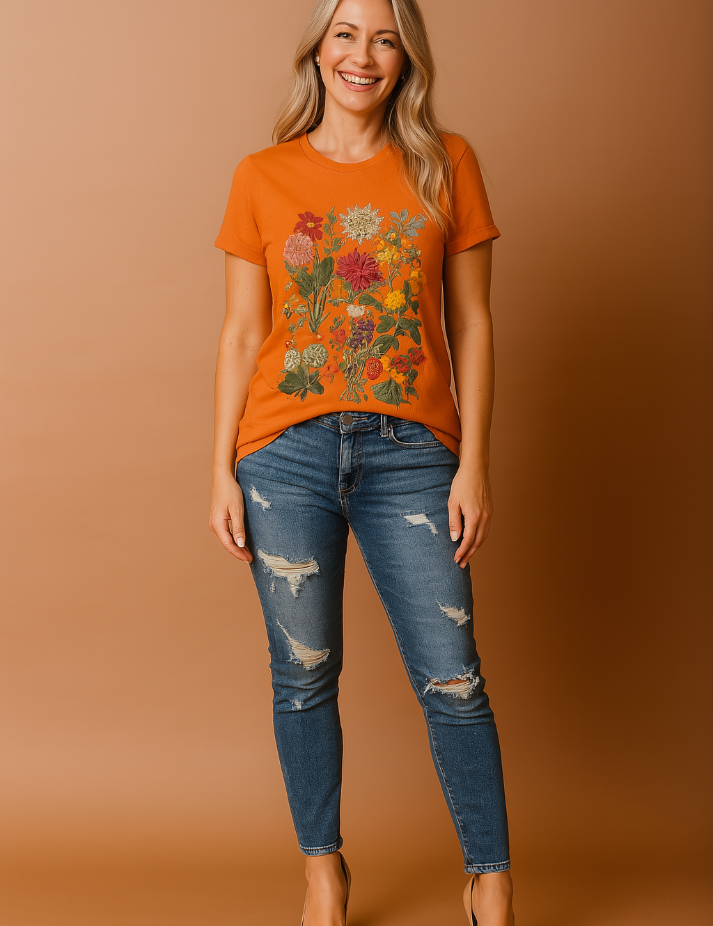 Oranje T-shirt met ronde hals en levendige bloemenprint in natuurlijke kleuren, waaronder rood, zalmroze, geel en groen, in een symmetrische opstelling op het midden van het shirt.