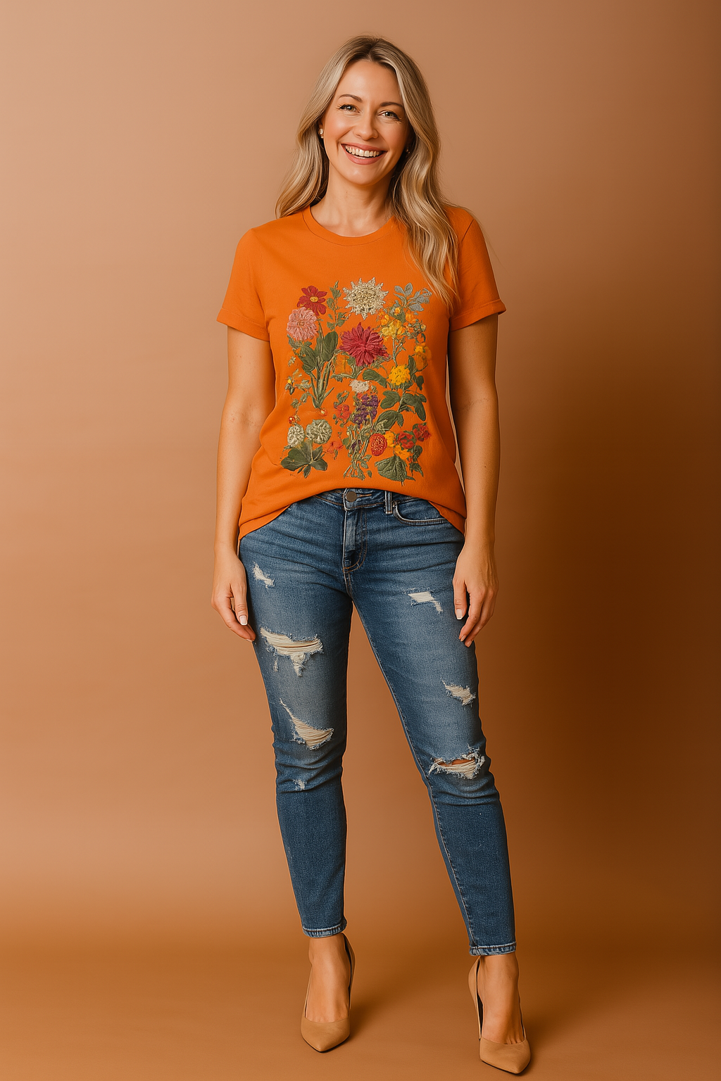 Oranje T-shirt met ronde hals en levendige bloemenprint in natuurlijke kleuren, waaronder rood, zalmroze, geel en groen, in een symmetrische opstelling op het midden van het shirt.