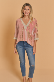 Roze blouse met abstract goud patroon, V-hals met kanten boord en 3/4 mouwen, vervaardigd van licht glanzende stof met marmerachtige details.

