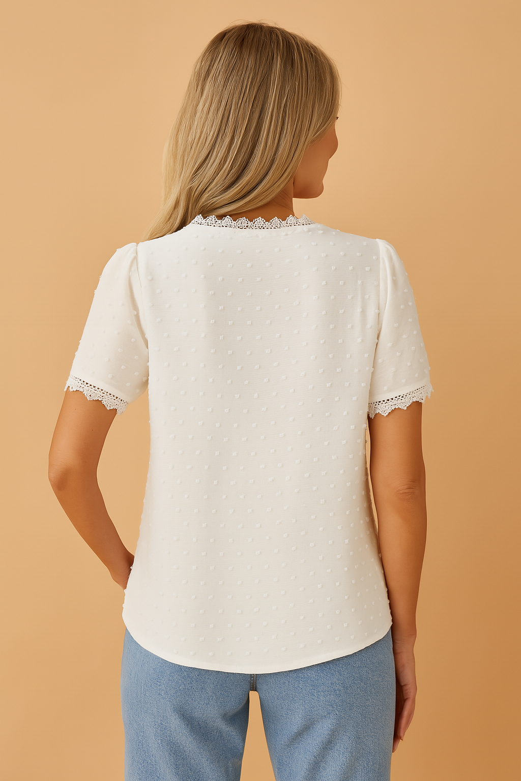 Witte blouse met korte mouwen, V-hals met kanten afwerking en subtiele stipstructuur, vervaardigd uit lichtgewicht stof met broderie-details aan de mouwranden.