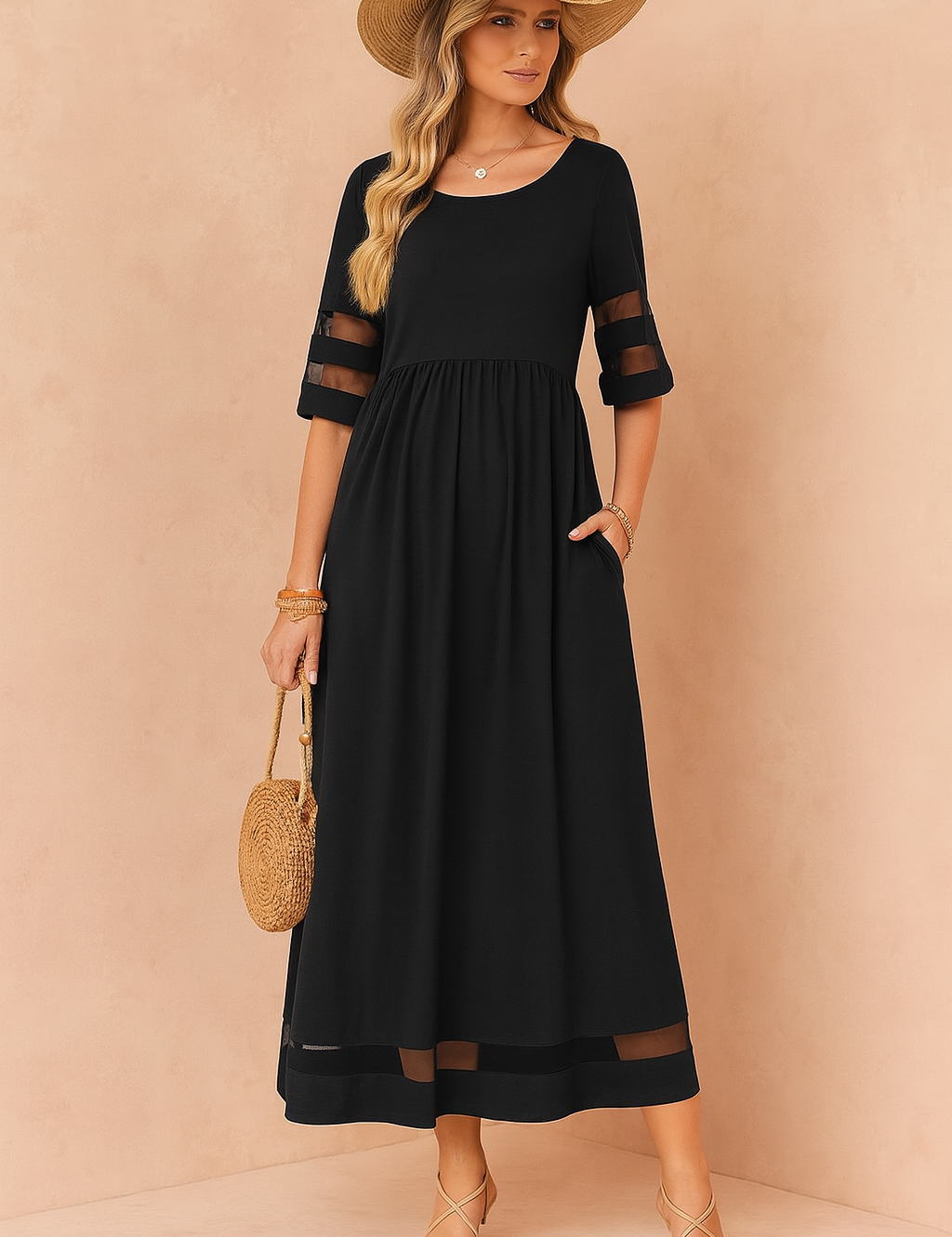 Zwarte maxi zomerjurk met transparante mouwen en inzetstukken, ideaal voor elegante en luchtige looks.