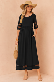Zwarte maxi zomerjurk met transparante mouwen en inzetstukken, ideaal voor elegante en luchtige looks.