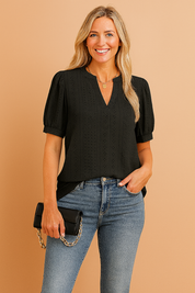 Zwarte blouse met korte pofmouwen en verticaal geperforeerd patroon, afgewerkt met een elegante V-hals.