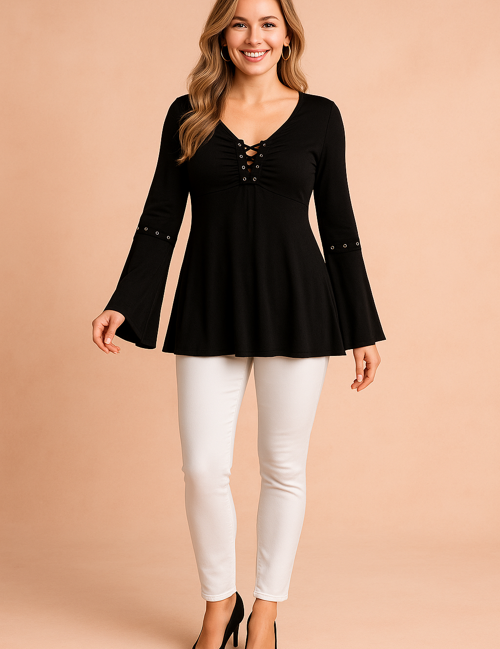 Zwarte tuniekblouse met vetersluiting en uitlopende mouwen. Deze effen zwarte top is gemaakt van een zachte stretchstof, voorzien van een diepe V-hals met gekruiste veterdetails, sierlijke studs op de mouwen en een subtiel A-lijn silhouet.