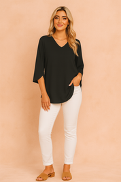 Zwarte blouse met V-hals en elegante vlindermouwen, perfect voor een chique en minimalistische outfit.